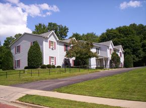 Meadville apartment for rent - a white house with red shuttered windows on the side of a street