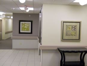 Erie apartment for rent - a hallway with a table and a chair and paintings on the wall