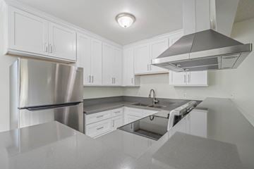 Gardena apartment for rent - A modern kitchen with a stainless steel refrigerator and a range hood.