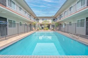 Gardena apartment for rent - A swimming pool in a residential area surrounded by buildings.