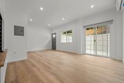 Los Angeles apartment for rent - A spacious room with wooden flooring and a sliding glass door.