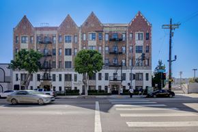 Los Angeles apartment for rent - A street view of a large white building with a sign that reads