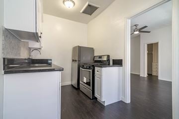 Los Angeles apartment for rent - A kitchen with white cabinets and a black countertop.