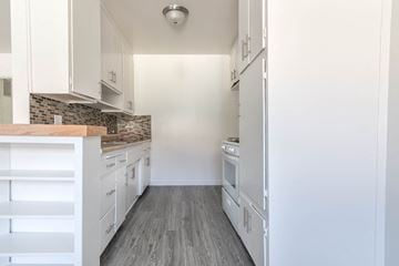 Canoga Park apartment for rent - A kitchen with white cabinets and a tile backsplash.