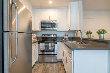 Los Angeles apartment for rent - A modern kitchen with a stainless steel refrigerator and white cabinets.
