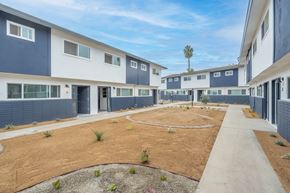 Covina apartment for rent - A courtyard surrounded by apartment buildings with a clear blue sky above.