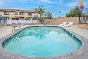 Covina apartment for rent - A small pool with a metal fence and a house in the background.