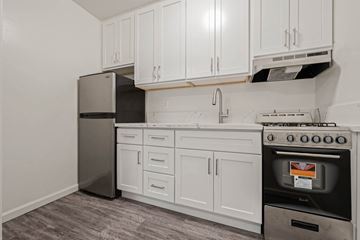 Los Angeles apartment for rent - A kitchen with white cabinets and a black fridge.