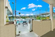 Los Angeles apartment for rent - A balcony with a glass door and a bench overlooking a pool.
