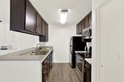 Canyon Country apartment for rent - A kitchen with dark brown cabinets and white appliances at Monterra Ridge Apartments, Canyon Country