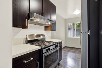 Downey apartment for rent - A kitchen with a stove top oven and a refrigerator.