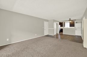 Downey apartment for rent - A spacious living room with a carpeted floor and a ceiling fan at The Square in Downey, CA, 90242