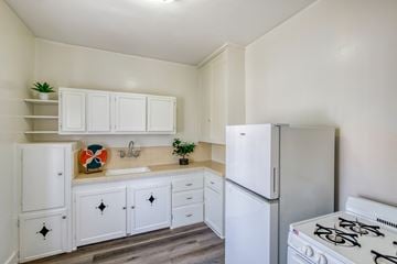 Los Angeles apartment for rent - A white kitchen with a stove, sink, and cabinets.
