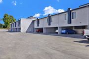 Reseda apartment for rent - A parking lot with a blue car parked in front of a building.
