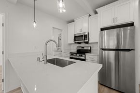 Los Angeles apartment for rent - A modern kitchen with stainless steel appliances and white cabinetry.