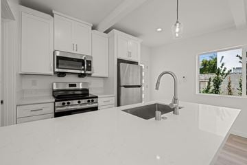 Los Angeles apartment for rent - A modern kitchen with white cabinets and appliances.