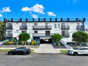 Los Angeles apartment for rent - A black car is parked in front of a white building with the number 3245 on it.