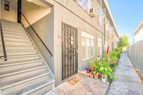 Los Angeles apartment for rent - A staircase with a metal railing leads up to a door.
