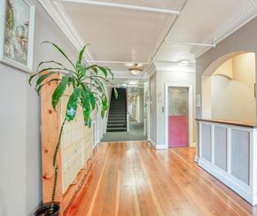 Los Angeles apartment for rent - A long hallway with a plant on the left and a staircase in the middle.