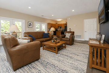 Asheville apartment for rent - A living room with brown leather furniture and a flat screen TV mounted on the wall.