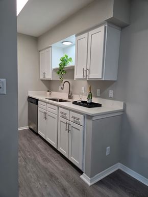 Morrisville apartment for rent - A kitchen with white cabinets and a black countertop.
