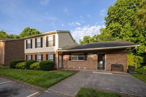 Winston Salem apartment for rent - A building with a grey roof and a sign that says "101" on it.