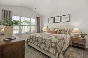 Whitsett apartment for rent - A bedroom with a large bed and a wooden nightstand.