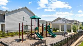 Whitsett apartment for rent - A playground with a green slide and a red pole.