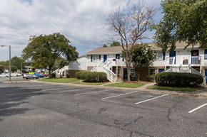 Greensboro apartment for rent - A parking lot in front of a building with a white fence.