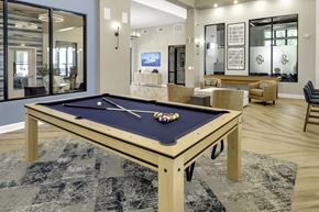 Greensboro apartment for rent - A pool table with a blue cloth and white balls is in the center of the room.