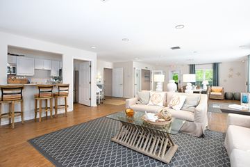 Wilmington apartment for rent - A modern living room with a glass coffee table and a grey rug.