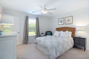 Wilmington apartment for rent - A bedroom with a bed, nightstand, and a ceiling fan.