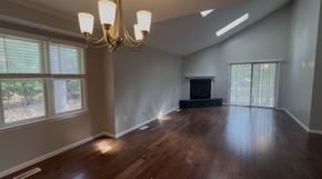 Fayetteville apartment for rent - A large empty room with a chandelier and a fireplace.
