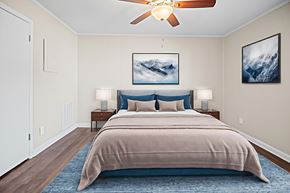 Fayetteville apartment for rent - A bedroom with a large bed and a ceiling fan.