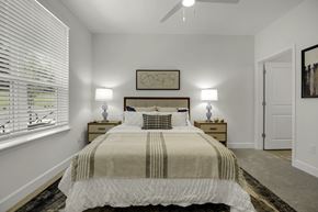 Greensboro apartment for rent - A bedroom with a large bed and a ceiling fan.