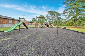 Fayetteville townhouse for rent - A playground with a green slide and a wooden swing set.