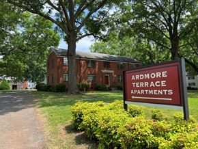 Winston-Salem apartment for rent - a red brick apartment building with a red sign in front of it