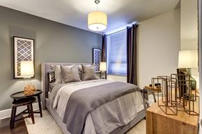 Norfolk apartment for rent - A bedroom with a large bed and a side table with a bottle on it.
