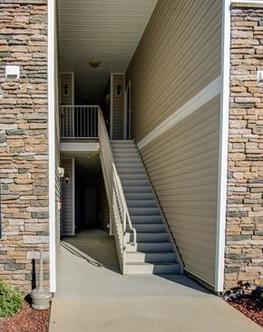 Fayetteville apartment for rent - A staircase with a metal railing leads to a doorway.