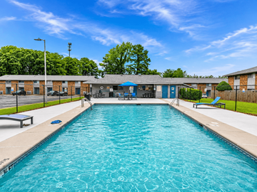 Fayetteville townhouse for rent - A large outdoor swimming pool with a blue sky and trees in the background.