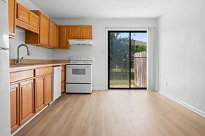 Fayetteville apartment for rent - A kitchen with wooden cabinets and a white fridge.