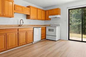 Fayetteville apartment for rent - A kitchen with wooden cabinets and a white dishwasher.