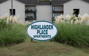 Fayetteville apartment for rent - A sign for Highlander Place Apartments in front of a building.
