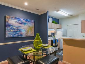 Asheville apartment for rent - A dining area with a glass table and a green vase on it.