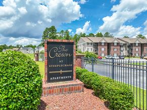 Parkton apartment for rent - A sign for The Crest at Steeplechase Apartments is in front of a building.
