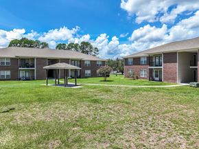 Hope Mills apartment for rent - A grassy area in front of apartment buildings with a pavilion in the middle.