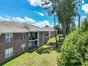 Hope Mills apartment for rent - A row of houses with green lawns and trees.
