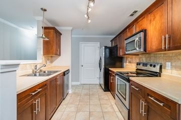 Parkton apartment for rent - A kitchen with brown cabinets and a black refrigerator.