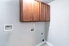 Parkton apartment for rent - A white wall with a brown cabinet and a white switchboard.