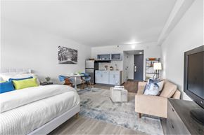 Fayetteville apartment for rent - A modern bedroom with a large bed and a chair with a blue cushion.